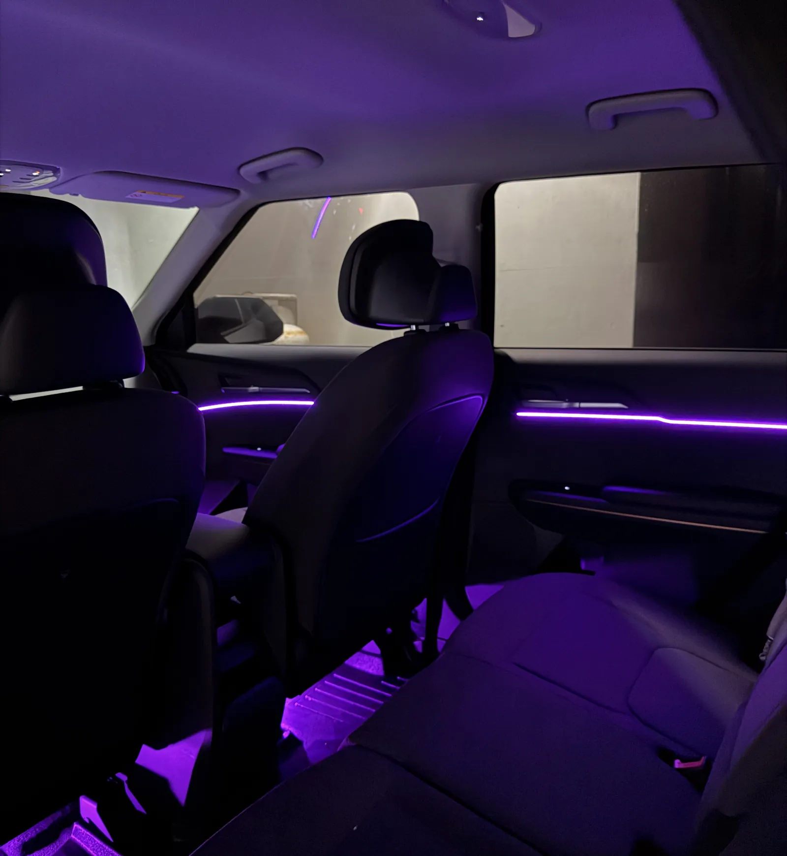 Purple ambient lighting through the rear cabin of a Kia EV5