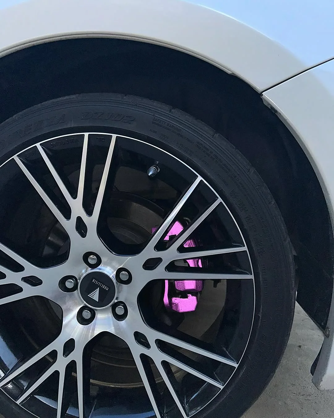Pink wrapped brake caliper seen through a Toyota GT86 wheel