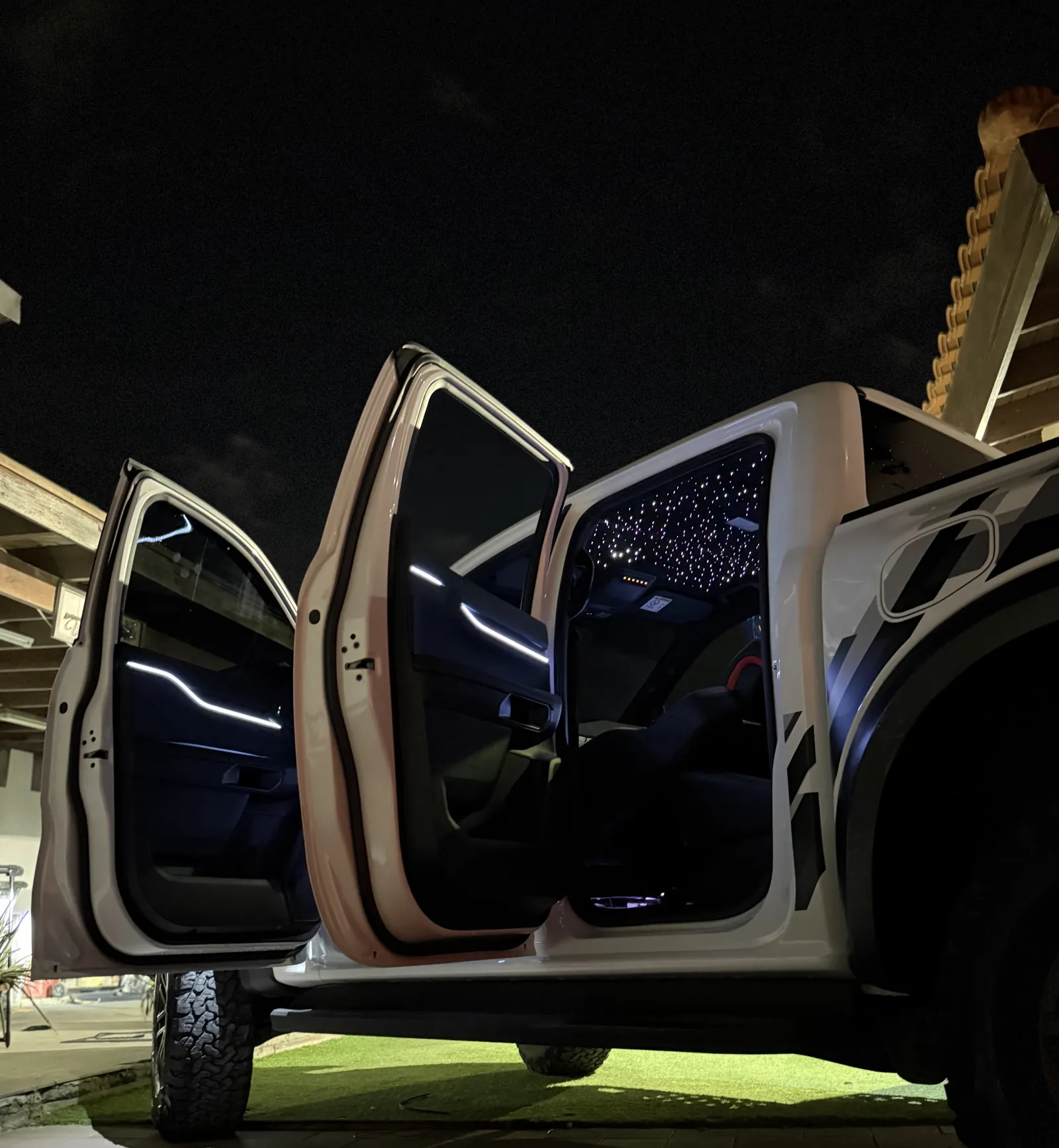 Ambient light lines glowing in an open-door Ranger Raptor at night